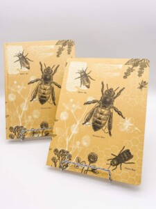 2 yellow notebooks with bees imprinted on them